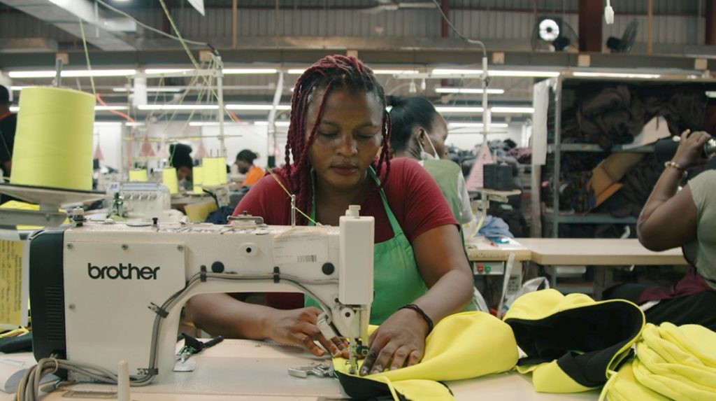 An Ethical Apparel employee assembles a garment with a sewing machine